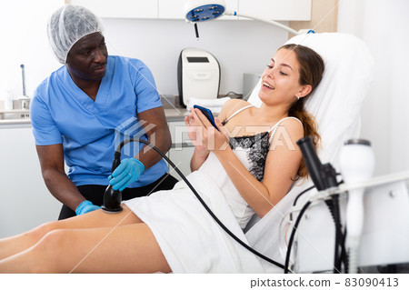 Cosmetologist reducing cellulite on the hips of a female patient Cosmetologist reducing cellulite on the hips of a female patient 83090413