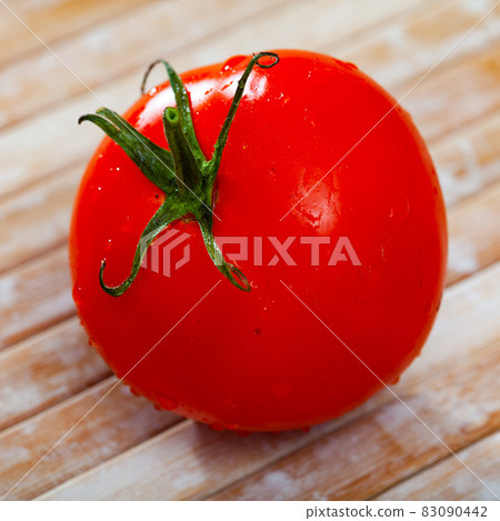 One red tomato on wooden table 83090442