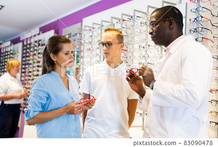 Male and female looking glasses frames, ophthalmologist helping 83090478