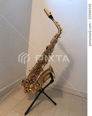 Alto saxophone leaning against the saxophone stand 83090540