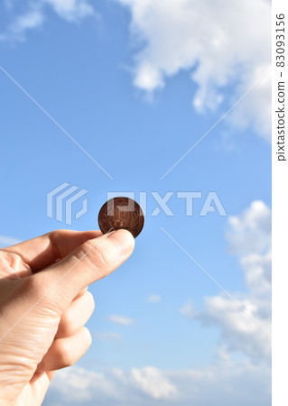 Hand with blue sky and 10-yen coin 02 Hand with blue sky and 10-yen coin 02 83093156