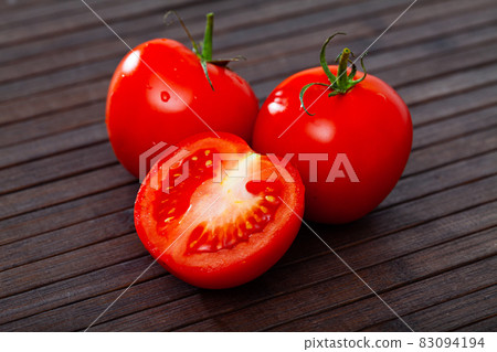Close up of red tomatoes on wooden surface Close up of red tomatoes on wooden surface 83094194