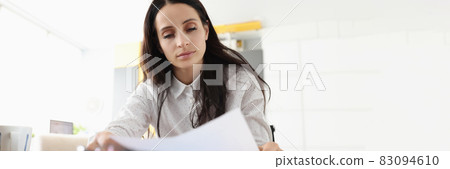 Woman sit at desk hold document read paper letter feels disappointed shocked by bad news Woman sit at desk hold document read paper letter feels disappointed shocked by bad news 83094610