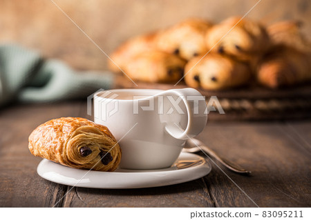 White cup of tea with mini chocolate bun 83095211