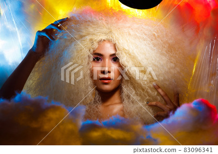 Half Body Portrait of 20s Asian Caucasian beautiful Woman blonde afro hair high fashion make up 83096341