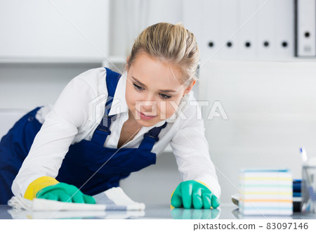 Workwoman wiping dust in office Workwoman wiping dust in office 83097146