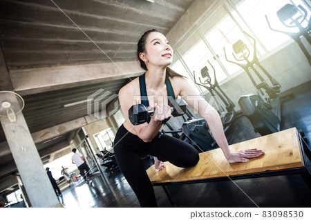 Sport asian women lifting dumbbell in gym Sport asian women lifting dumbbell in gym 83098530
