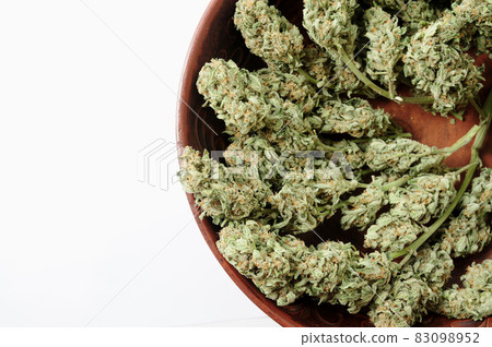 Cannabis buds in brown clay dish, flat lat, top view. Cannabis buds in brown clay dish, flat lat, top view. 83098952