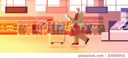 senior woman with full of products trolley cart checking shopping list in supermarket modern grocery shop interior senior woman with full of products trolley cart checking shopping list in supermarket modern grocery shop interior 83098958