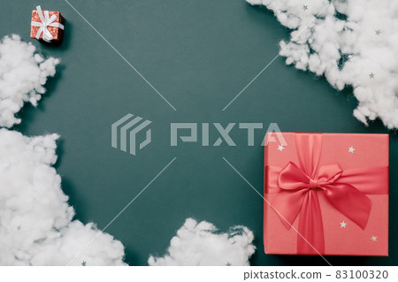 Composition of two red gift boxes and a fiberfil on an emerald background. Holiday postcard Composition of two red gift boxes and a fiberfil on an emerald background. Holiday postcard 83100320