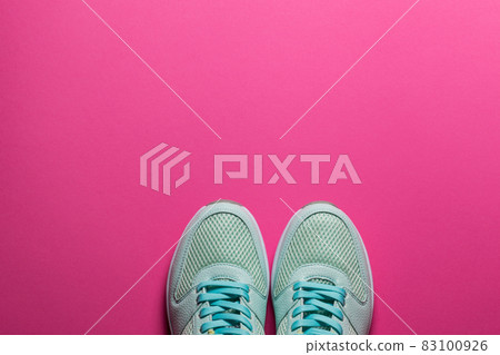 Turquoise sneakers with white soles on a pink background close-up Turquoise sneakers with white soles on a pink background close-up 83100926