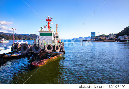 It is a harbor scenery where you can see the tugboat. Please in the background of the seascape. -2 83102491