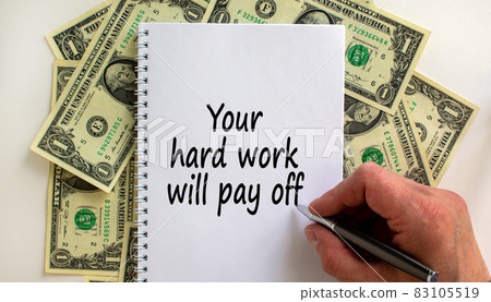 Male hand writing 'your hard work will pay off' on white note, on white background. Dollar bills. 83105519