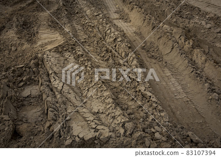 Wheel trail on sandy ground from large transport, tractor on construction site, sandy road Wheel trail on sandy ground from large transport, tractor on construction site, sandy road 83107394