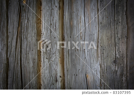 Wooden logs of an old house. Close-up. Weathered natural gray wood texture. Background. Horizontal photo. Wooden logs of an old house. Close-up. Weathered natural gray wood texture. Background. Horizontal photo. 83107395