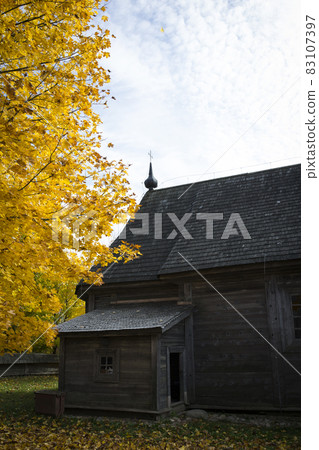 Autumn landscape. Yellow foliage on the trees and a rustic wooden church. Autumn landscape. Yellow foliage on the trees and a rustic wooden church. 83107397
