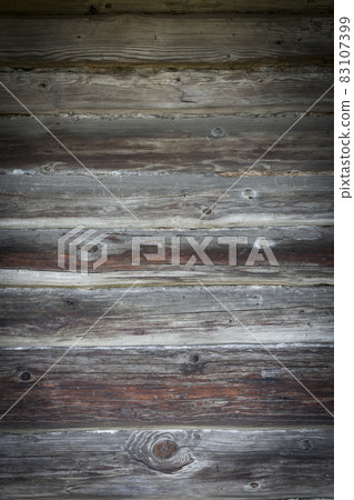 Wooden logs of an old house. Close-up. Weathered natural gray wood texture. Background. vertical photo. Wooden logs of an old house. Close-up. Weathered natural gray wood texture. Background. vertical photo. 83107399