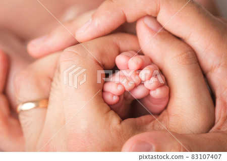 Loving parent hold baby's legs. Happy childhood. Parental care. Loving parent hold baby's legs. Happy childhood. Parental care. 83107407