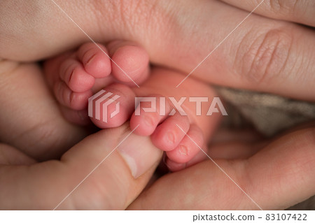 Loving parent hold baby's legs. Happy childhood. Parental care. Concept of a happy family. 83107422