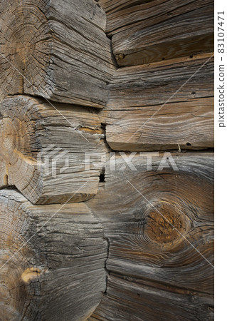 Wooden logs of an old house. Close-up. Weathered natural gray wood texture. Background. vertical photo. Wooden logs of an old house. Close-up. Weathered natural gray wood texture. Background. vertical photo. 83107471