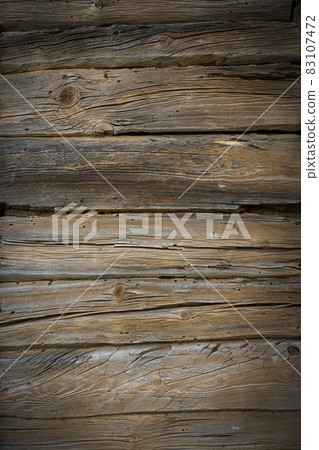 Wooden logs of an old house. Close-up. Weathered natural gray wood texture. Background. vertical photo. 83107472