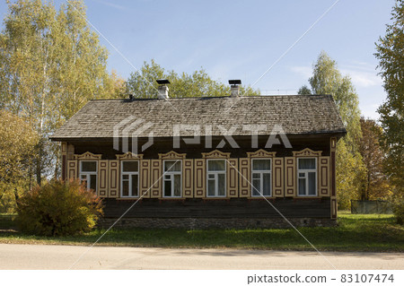 Abandoned wooden house in a dead village. Golden autumn. Old rustic architecture. Abandoned wooden house in a dead village. Golden autumn. Old rustic architecture. 83107474