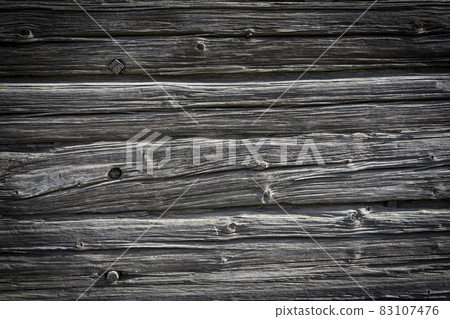 Wooden logs of an old house. Close-up. Weathered natural gray wood texture. Background. Horizontal photo Wooden logs of an old house. Close-up. Weathered natural gray wood texture. Background. Horizontal photo 83107476