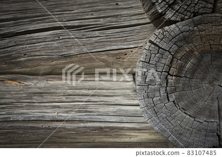 Wooden logs of an old house. Close-up. Weathered natural gray wood texture. Wooden logs of an old house. Close-up. Weathered natural gray wood texture. 83107485