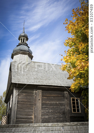 Autumn landscape. Yellow foliage on the trees and a rustic wooden church. Autumn landscape. Yellow foliage on the trees and a rustic wooden church. 83107489
