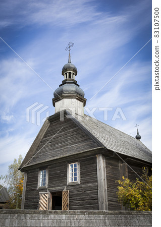 Autumn landscape. Yellow foliage on the trees and a rustic wooden church. Autumn landscape. Yellow foliage on the trees and a rustic wooden church. 83107500