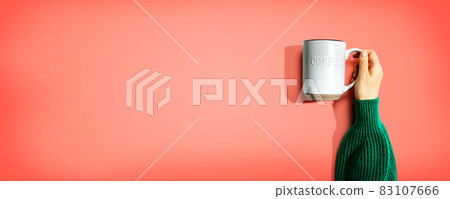 Female hand holding a mug overhead view 83107666
