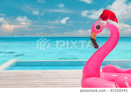 Christmas beach summer vacation flamingo pool float with santa hat travel background for winter holidays Christmas beach summer vacation flamingo pool float with santa hat travel background for winter holidays 83108341