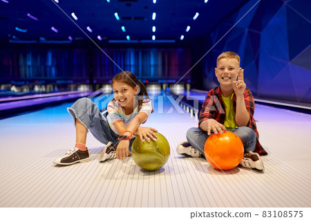 Children sitting on the lane in bowling alley 83108575