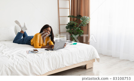 Black Woman Using Laptop Lying In Bed At Home, Panorama Black Woman Using Laptop Lying In Bed At Home, Panorama 83108753