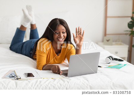 African Woman Video Calling Waving Hello To Laptop In Bedroom 83108758