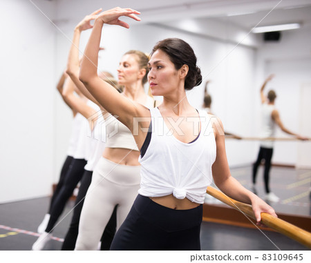 Woman practicing ballet elements in class Woman practicing ballet elements in class 83109645
