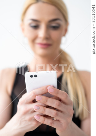 Gadget addiction. Happy woman. Mobile technology. Online lesson. Defocused smiling lady looking on smartphone in hands isolated white. 83110541