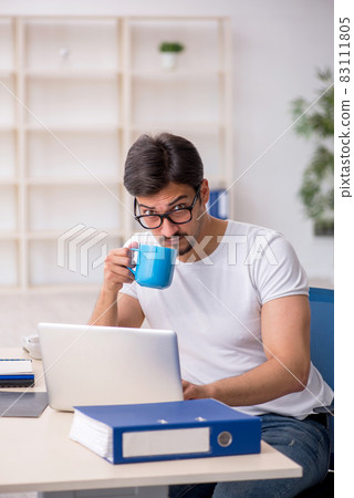 Young male employee drinking coffee during break 83111805