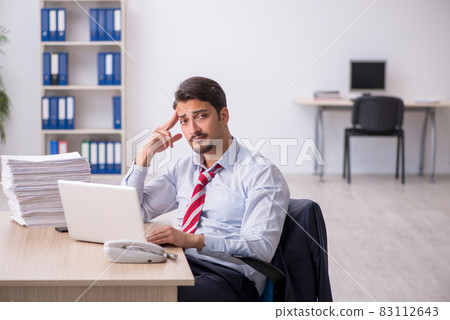Young male employee sitting at workplace Young male employee sitting at workplace 83112643