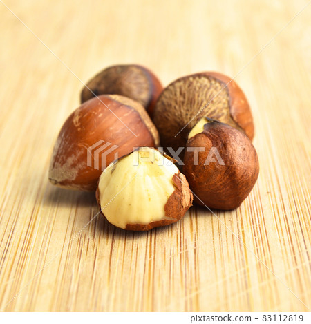 Fresh organic hazelnuts filbert, on bamboo cutting board Fresh organic hazelnuts filbert, on bamboo cutting board 83112819