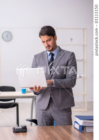Young male employee working in the office Young male employee working in the office 83113150