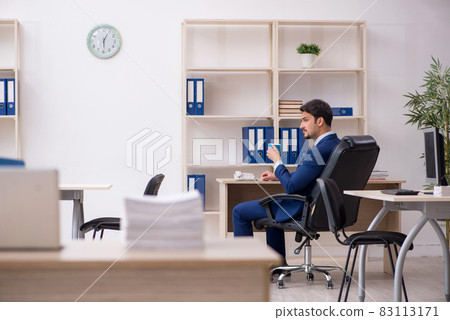 Young male employee drinking coffee during break Young male employee drinking coffee during break 83113171
