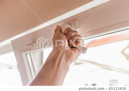 The guy's hand opens a plastic double window for the handle pvc double glazing 83113438