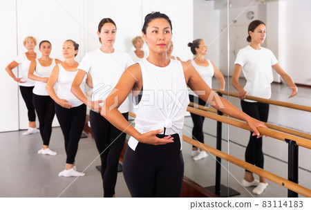 Women exercising ballet moves in training room Women exercising ballet moves in training room 83114183