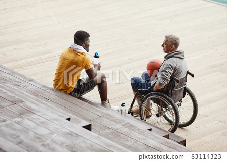 Man talking to athlete outdoors 83114323