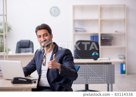 Young handsome employee working in the office Young handsome employee working in the office 83114338