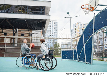 Friends in wheelchairs playing basketball Friends in wheelchairs playing basketball 83114444