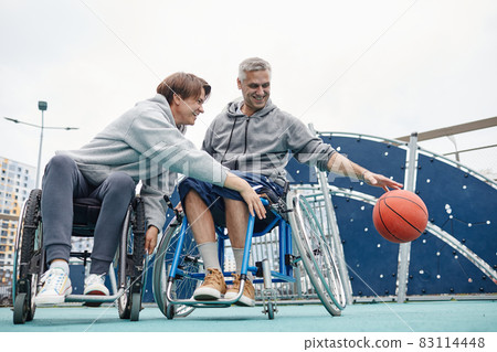 Couple of friends in wheelchairs playing together 83114448