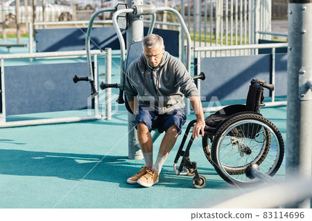 Man with disability visiting gym outdoors Man with disability visiting gym outdoors 83114696