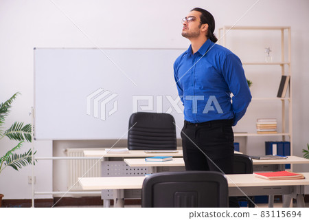 Young male teacher in front of whiteboard Young male teacher in front of whiteboard 83115694